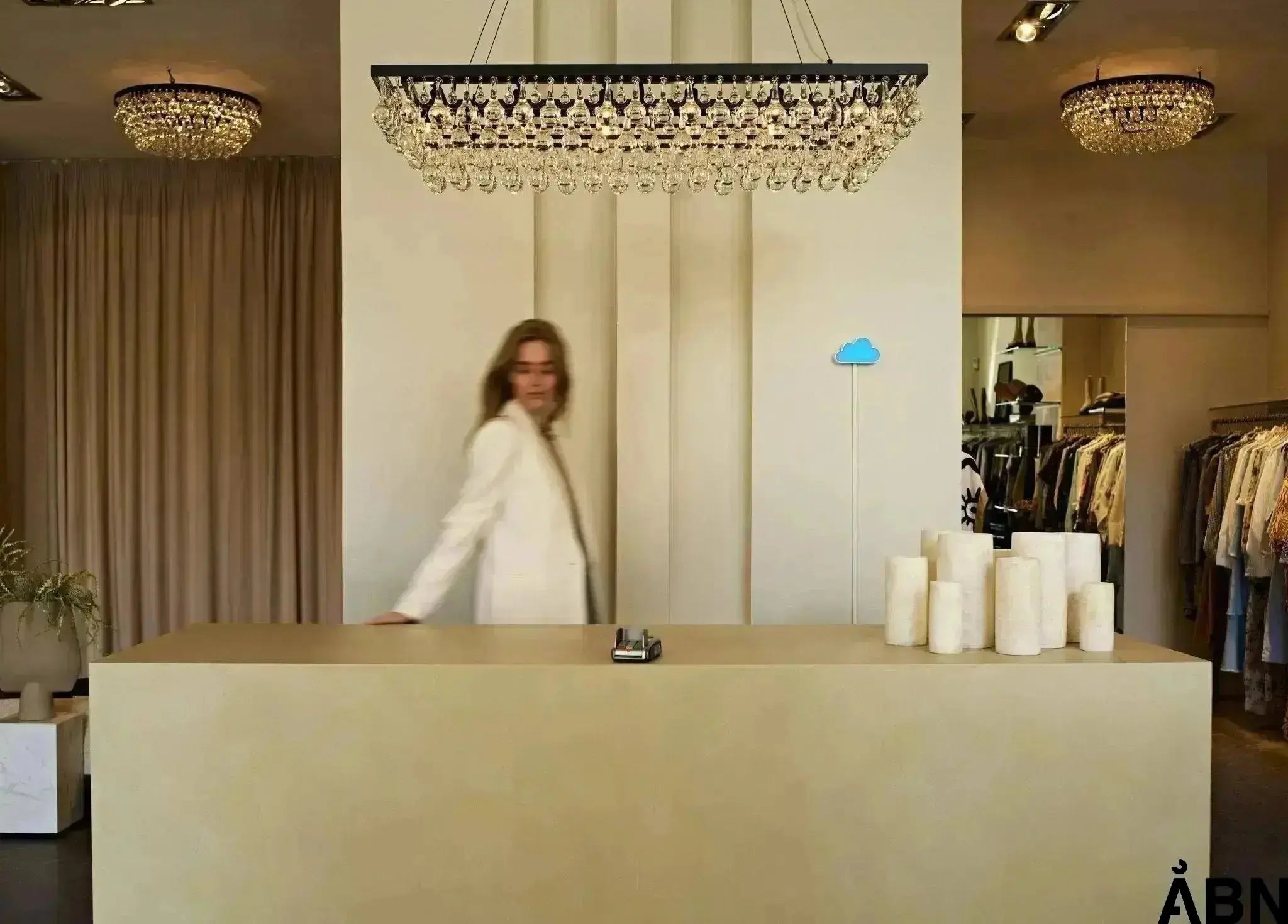 a woman is standing in a frontdesk with SKYEN CO2 sensor at the wall